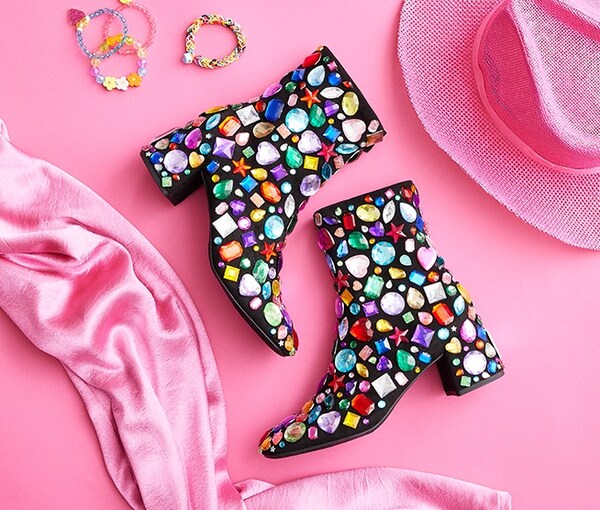Black jeweled boots on pink background with pink cowboy hat on a pink background